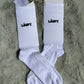 Weiße Tennis-Socke mit schwarzem „läuft“-Schriftzug im 90s-Stil, weiße Socken mit Motiv