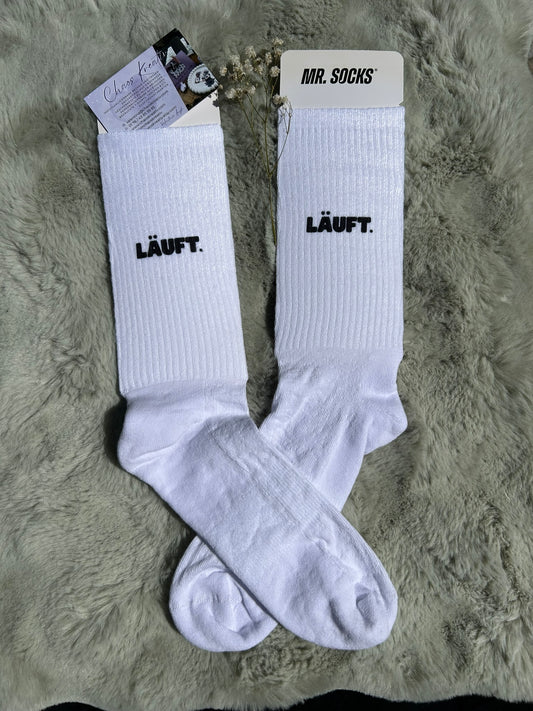 Weiße Tennis-Socke mit schwarzem „läuft“-Schriftzug im 90s-Stil, weiße Socken mit Motiv